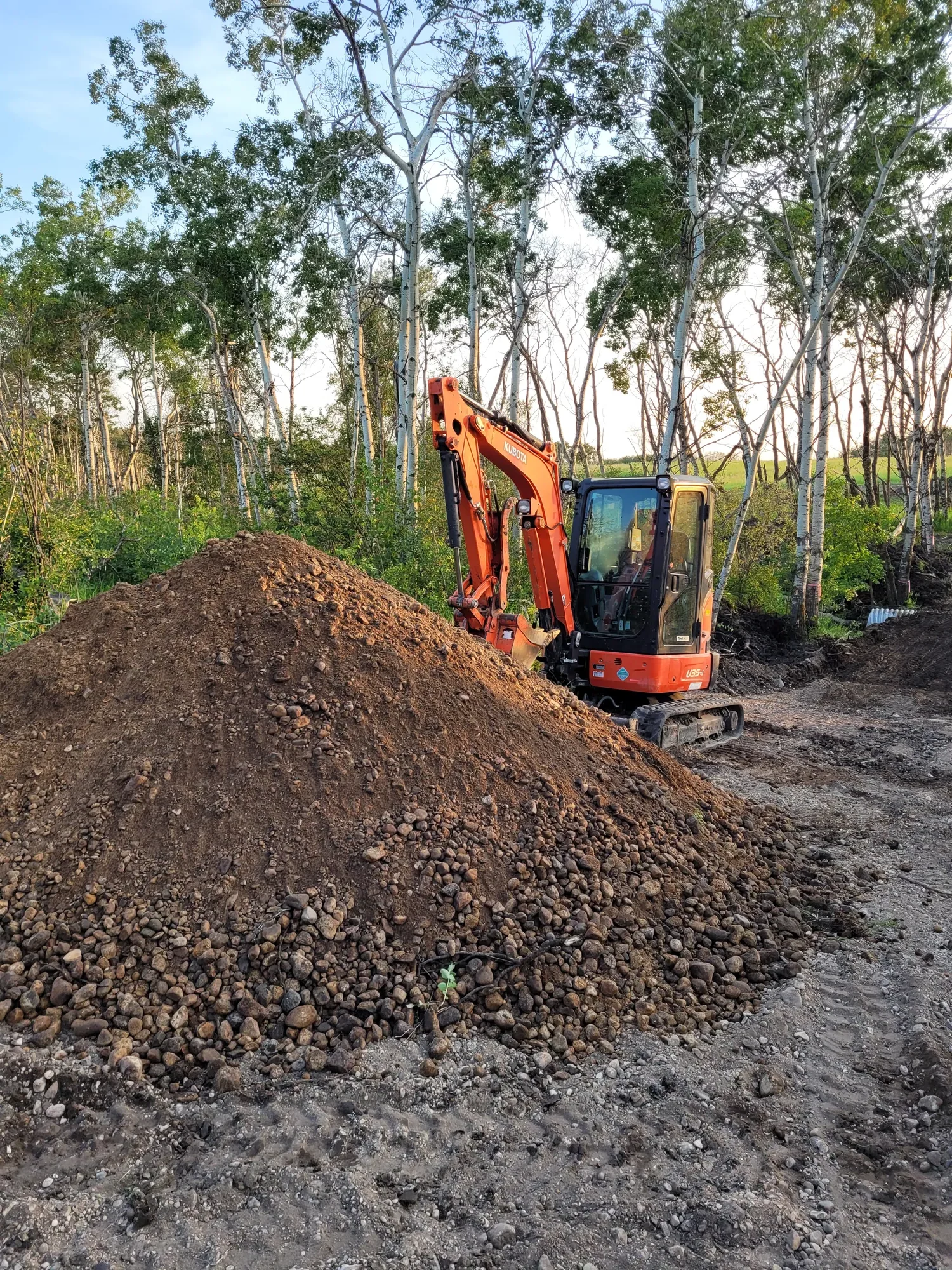 An excavator in front of a dirt pile ready for earthmoving